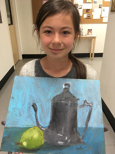 Young girl holding her painting of black coffee pot with lemon
