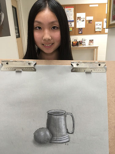 Young girl holding her charcoal drawing of metal mug with egg