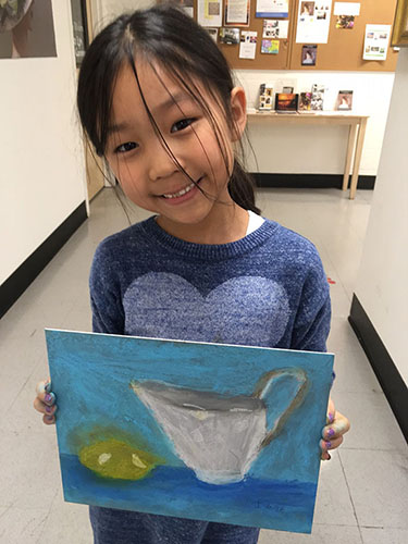 Young girl smiling with her pitcher painting