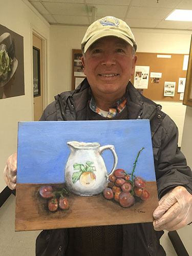 Adult student displaying his completed still life painting